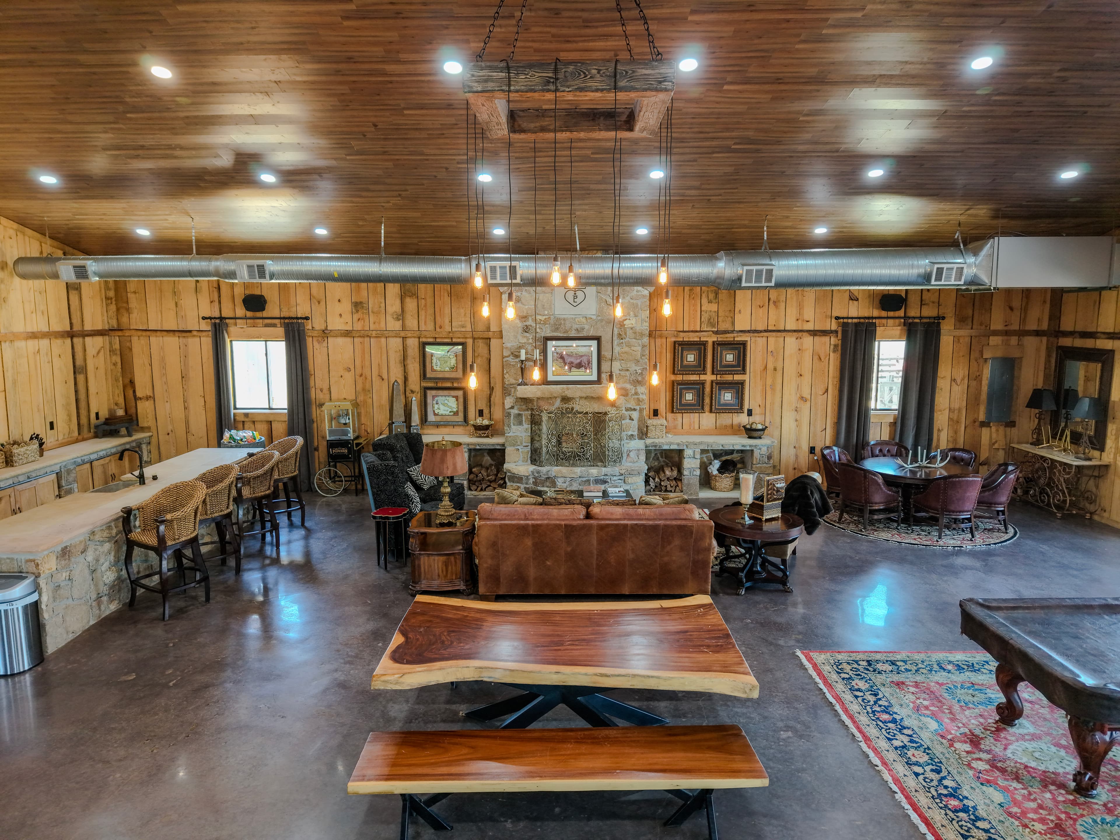 Interior view of a rustic venue space with a fireplace, seating, and wood walls