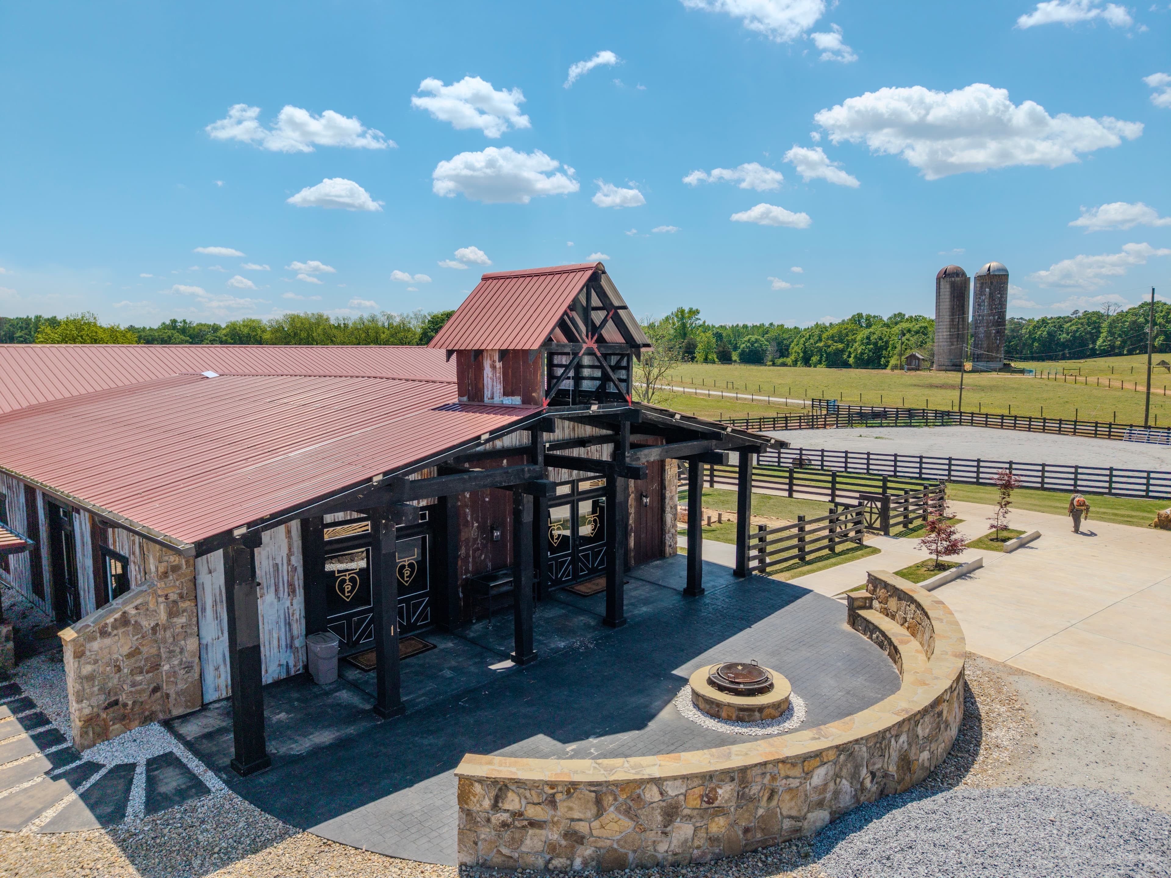 Angled aerial view of a rustic front entrance with a red roof and stone wall