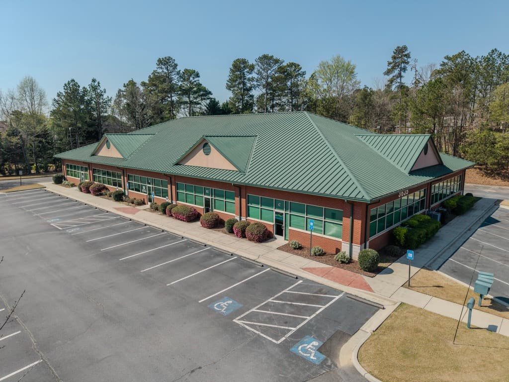 Angled aerial view of a professional office park with parking and landscaped frontage